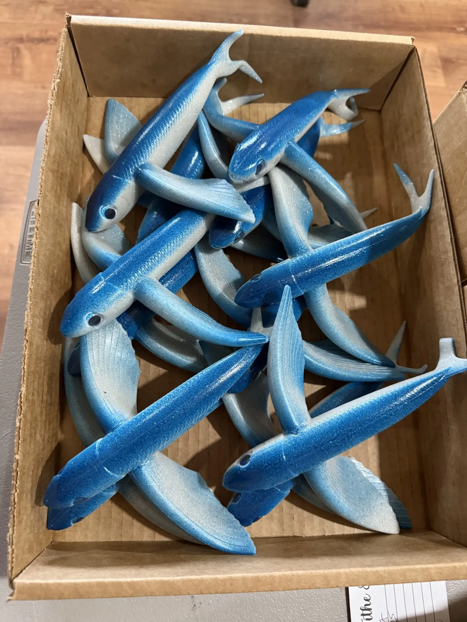 multiple blue shark figurines in a box
